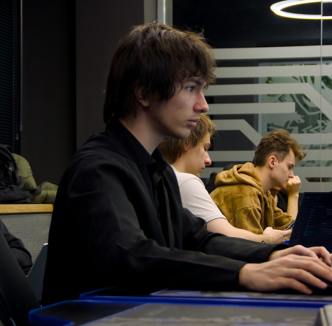 Two Portuguese developers pair programming at a shared desk