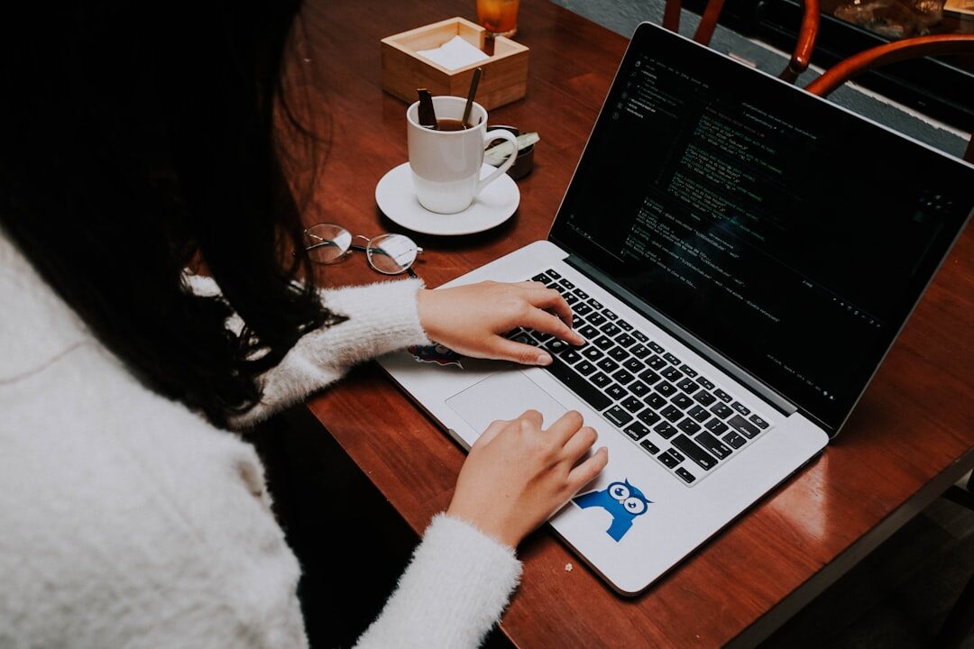 programmer writing code on laptop