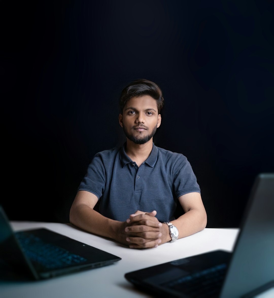 Portuguese man programmer working on a laptop at a desk