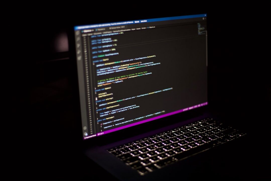 programmer writing code on laptop